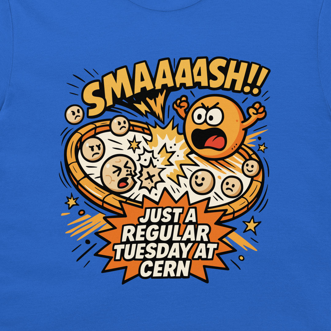 A close-up of a blue T-shirt featuring a colorful cartoon graphic of a pizza exploding with expressive faces and comic-style text reading 'SMAAAASH!!' and 'JUST A REGULAR TUESDAY AT CERN'.