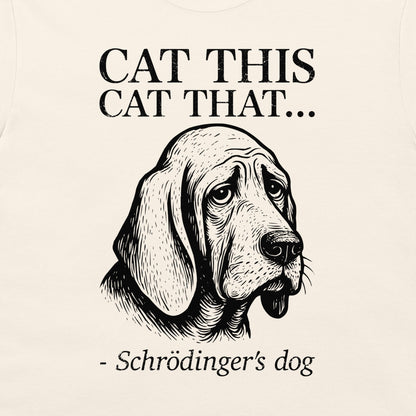 A close-up of a cream-colored t-shirt, featuring a black graphic print of a sad bloodhound Schrödinger's dog with the text 'CAT THIS CAT THAT.