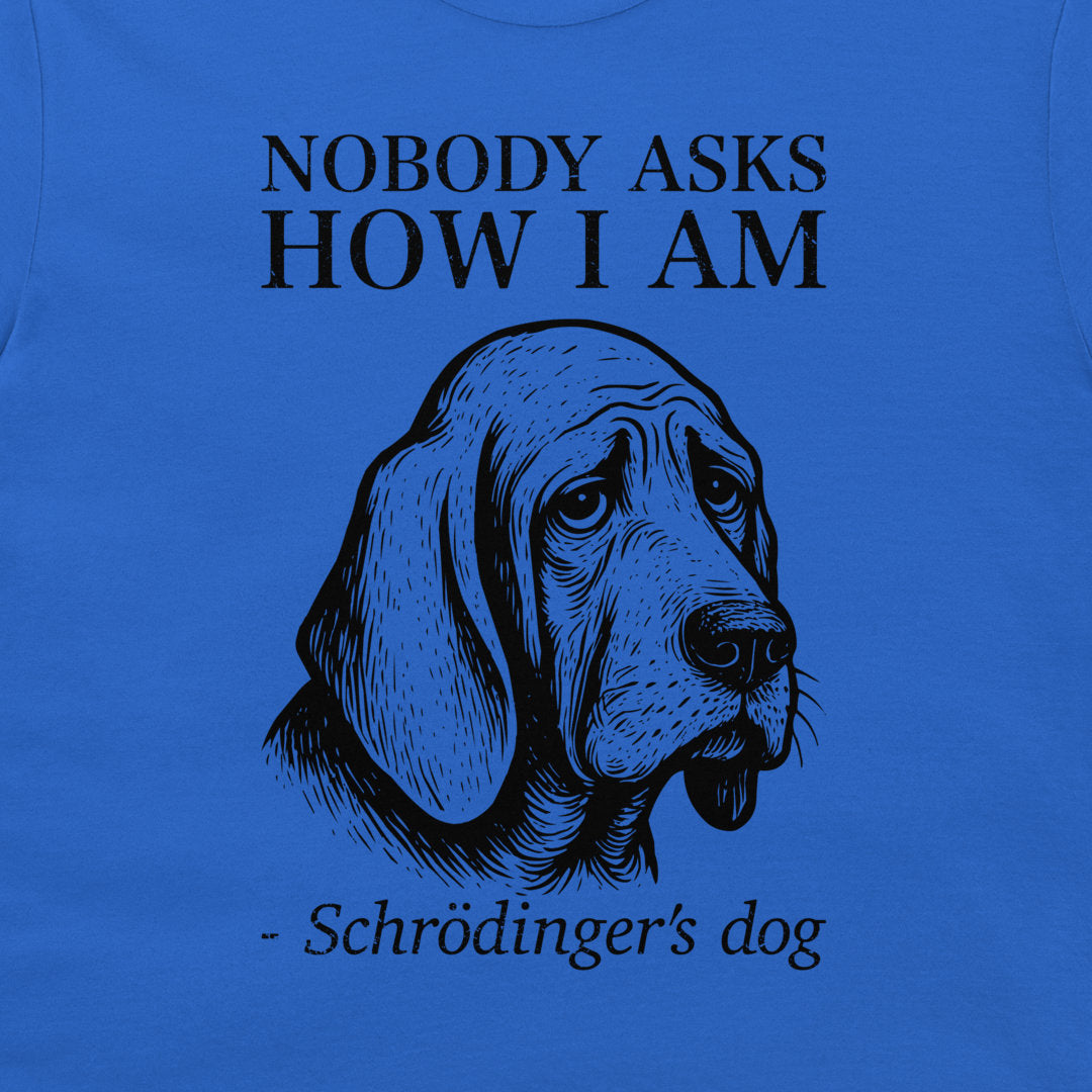 A close-up of a blue graphic print featuring a black line art illustration of a sad-looking dog with the text 'NOBODY ASKS HOW I AM' above and '- Schrödinger's dog' below.