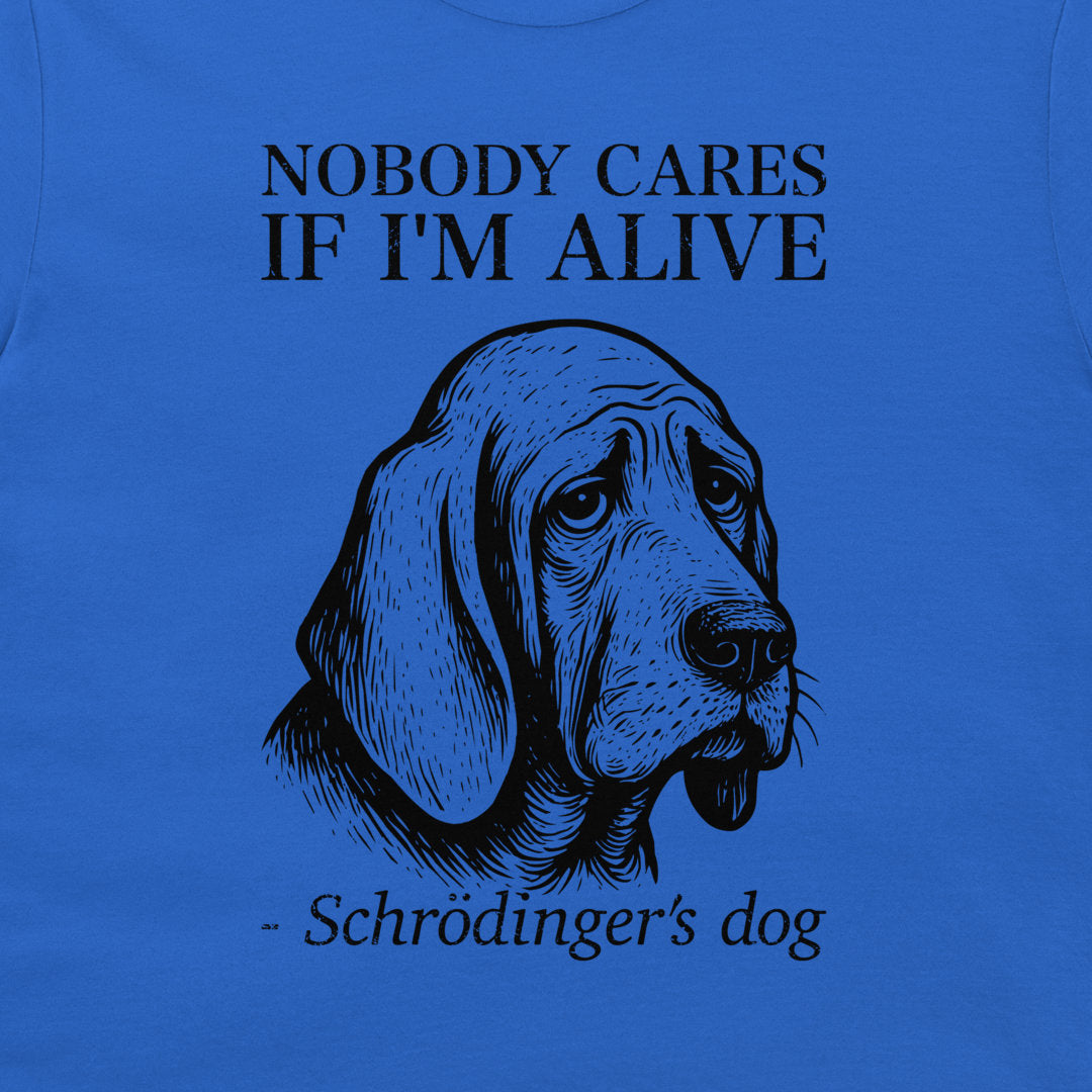 A blue graphic t-shirt featuring a black line art illustration of a sad dog with the text 'NOBODY CARES IF I'M ALIVE - Schrödinger's dog'.