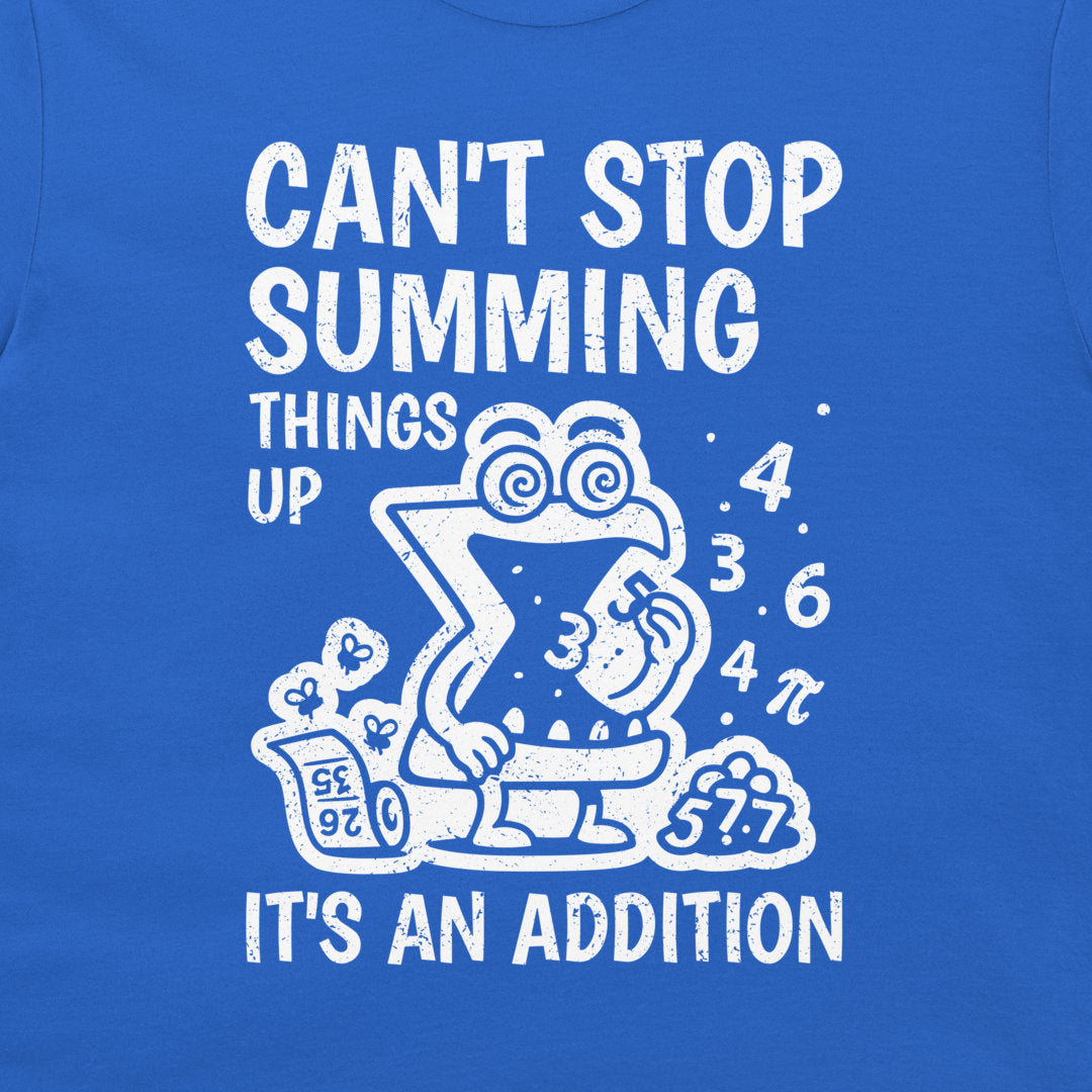 A close-up of a royal blue t-shirt featuring a white graphic print. The design shows a cartoon letter 'X' character in a toilet bowl with the text 'CAN'T STOP SUMMING THINGS UP' above and 'IT'S AN ADDITION' below, surrounded by numbers and a calculator.
