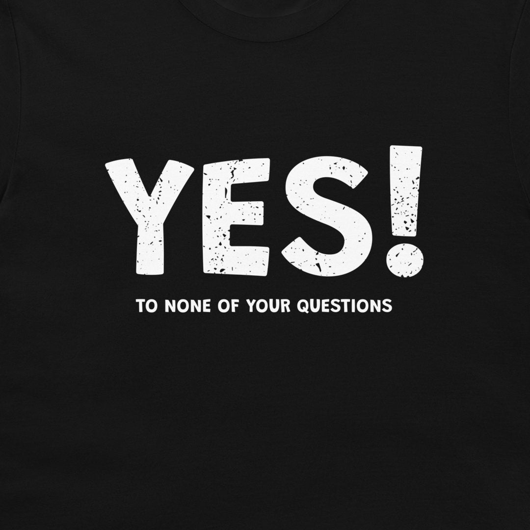 A close-up of a black T-shirt with a bold white distressed graphic reading 'YES!' and smaller text below reading 'TO NONE OF YOUR QUESTIONS'.