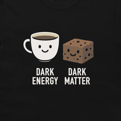 A close-up of a black t-shirt featuring a graphic print of a smiling white coffee mug labeled 'DARK ENERGY' next to a smiling brown chocolate chip cookie labeled 'DARK MATTER'.