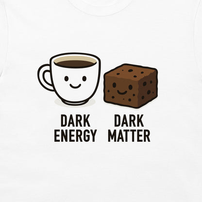 A white graphic t-shirt featuring a cute cartoon illustration of a smiling coffee cup labeled 'DARK ENERGY' next to a smiling brownie labeled 'DARK MATTER'.
