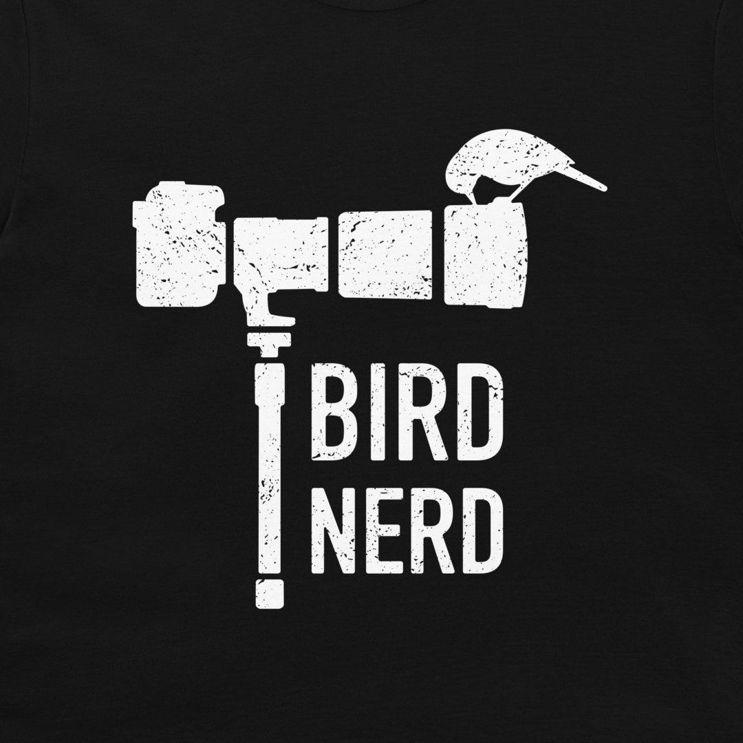 A black t-shirt featuring a distressed white graphic of a camera shaped like a bird perched on top, with the words 'BIRD NERD' printed below.