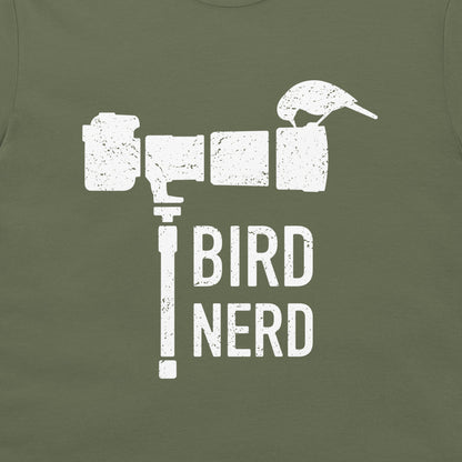 An olive green t-shirt featuring a distressed white graphic of a bird perched on a camera lens with the text 'BIRD NERD' printed below.