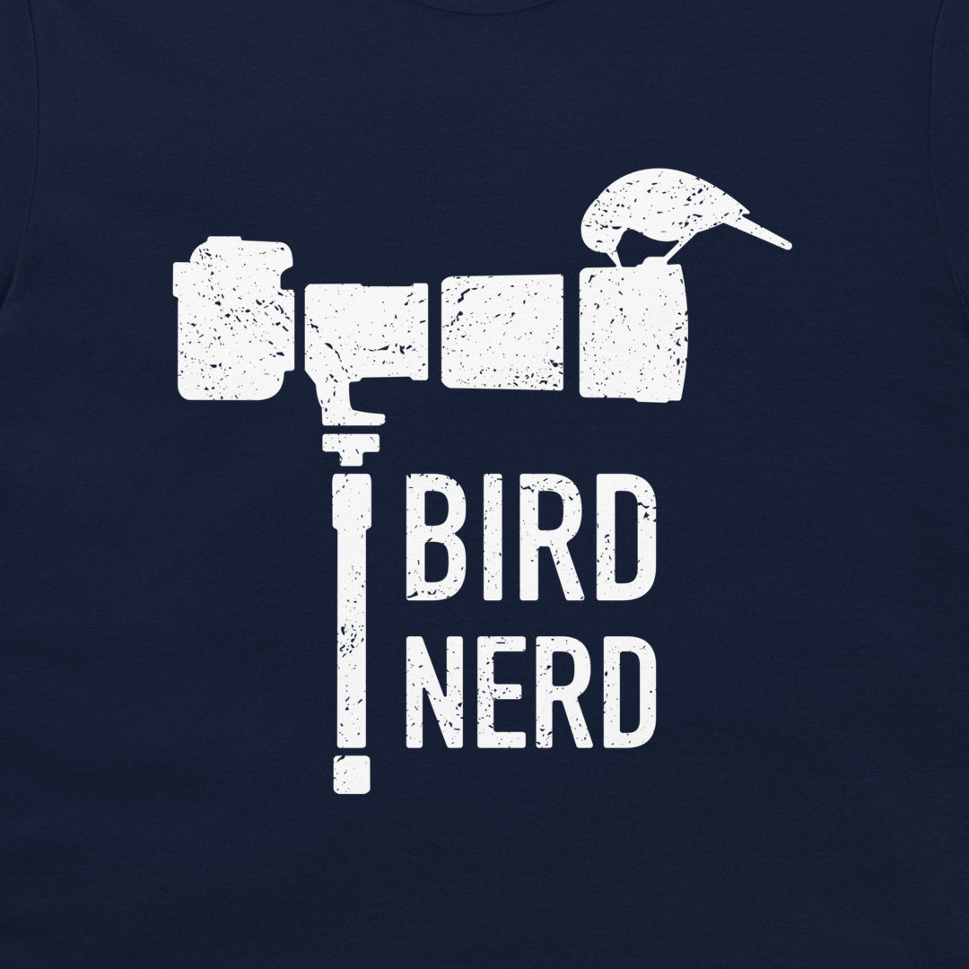 A close-up of a navy blue  t-shirt, featuring a distressed white graphic that spells 'BIRD NERD' with a bird perched on a camera-like object.