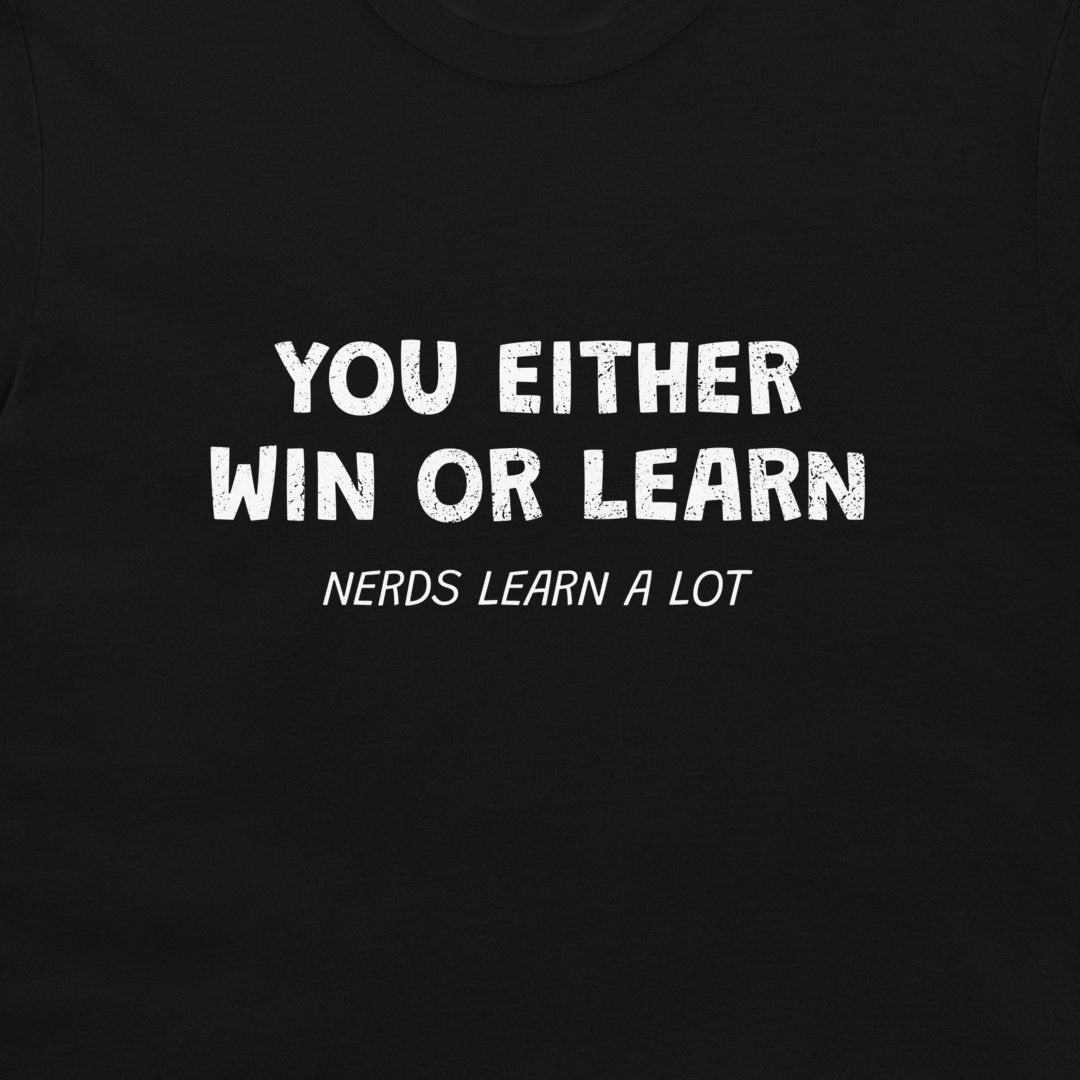 A close-up of a black t-shirt featuring a white distressed text graphic that reads 'YOU EITHER WIN OR LEARN' with 'NERDS LEARN A LOT' printed below in a smaller font.