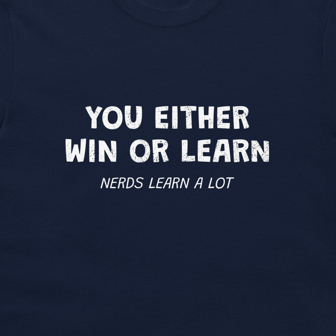 A close-up of a navy blue t-shirt featuring a white distressed text graphic that reads 'YOU EITHER WIN OR LEARN' with 'NERDS LEARN A LOT' written underneath.