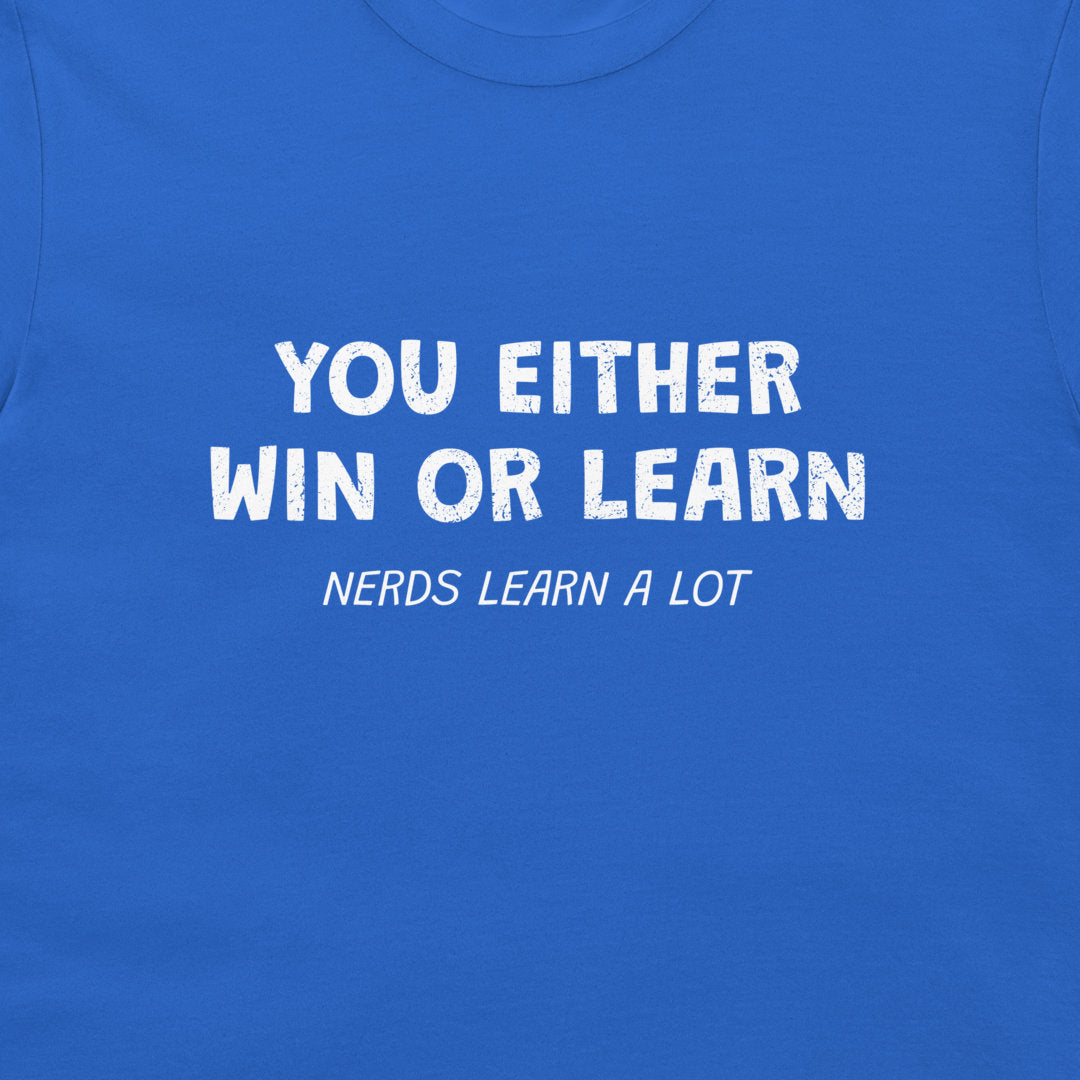 A close-up of a blue t-shirt featuring a white printed graphic that reads 'YOU EITHER WIN OR LEARN' with 'NERDS LEARN A LOT' underneath.