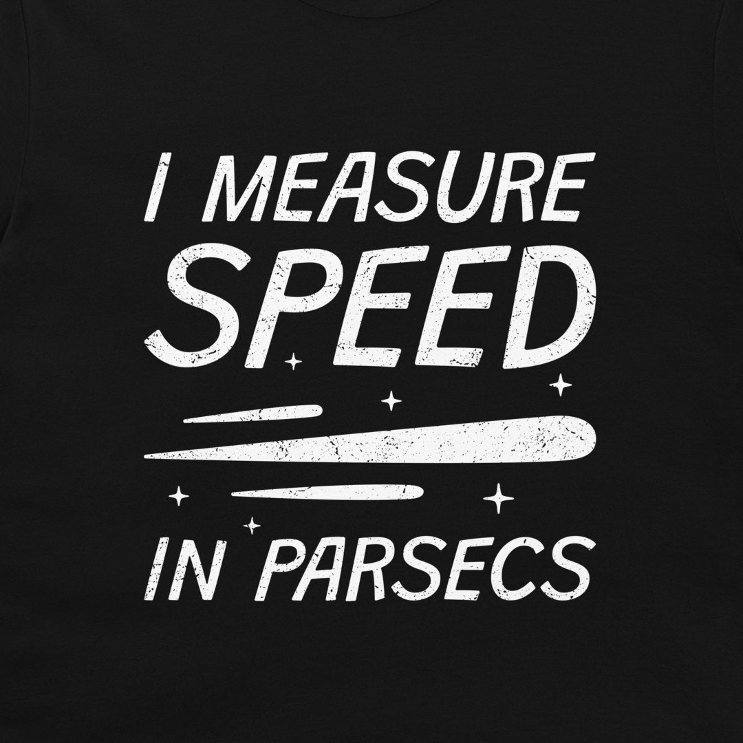 A close-up of a black t-shirt, featuring a distressed white graphic print that reads 'I MEASURE SPEED IN PARSECS' with a stylized streak and star elements.