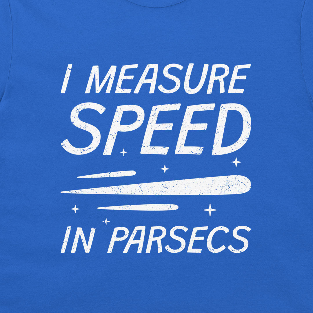 A close-up of a blue t-shirt featuring a white distressed graphic that reads 'I MEASURE SPEED IN PARSECS' with a stylized streak and stars.