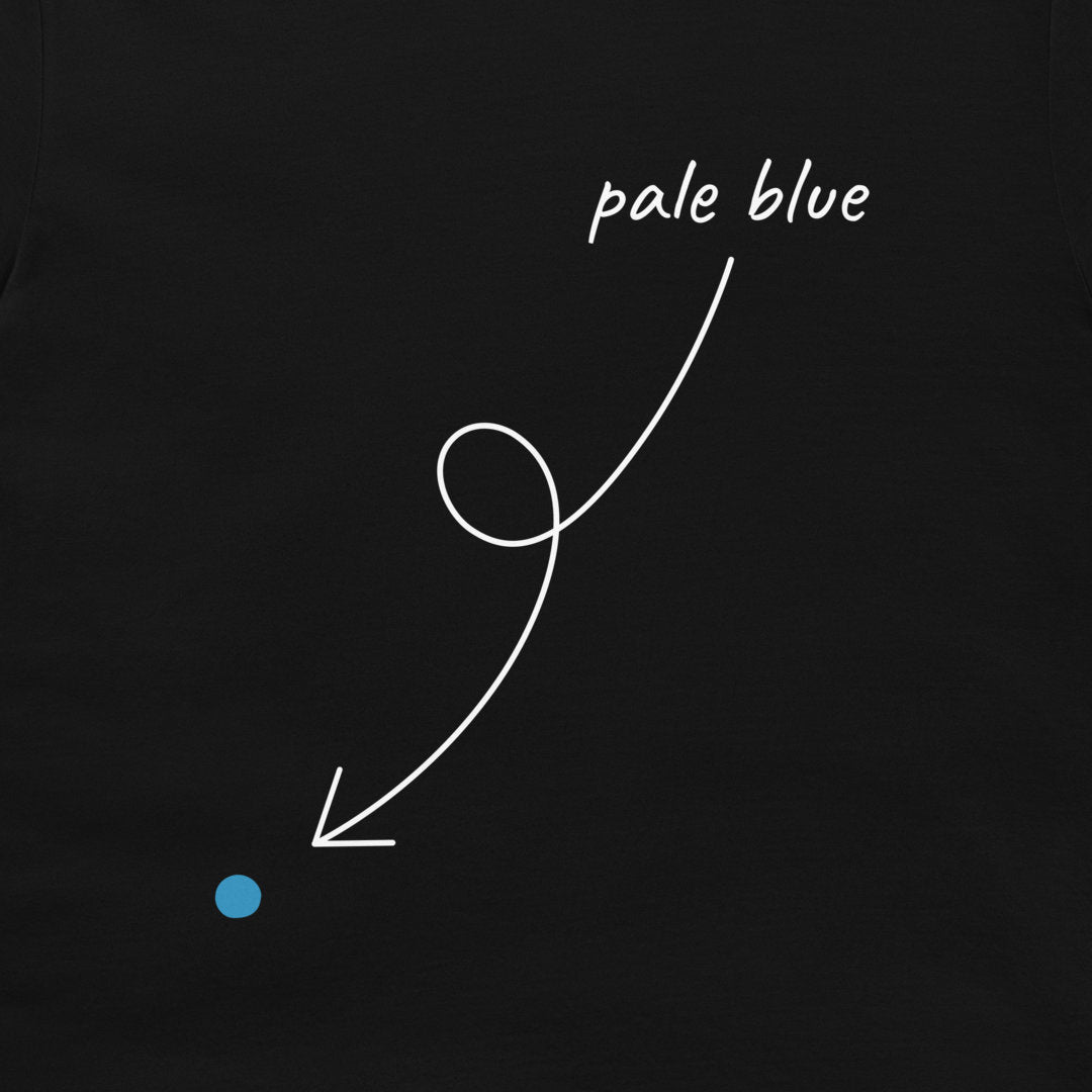 A close-up of a black T-shirt, featuring a white hand-drawn style arrow pointing from the text 'pale blue' to a small light blue dot.
