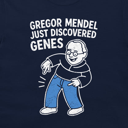 A close-up of a navy blue garment, likely a t-shirt, featuring a white and light blue graphic of a cartoon man with the text 'GREGOR MENDEL JUST DISCOVERED GENES'.