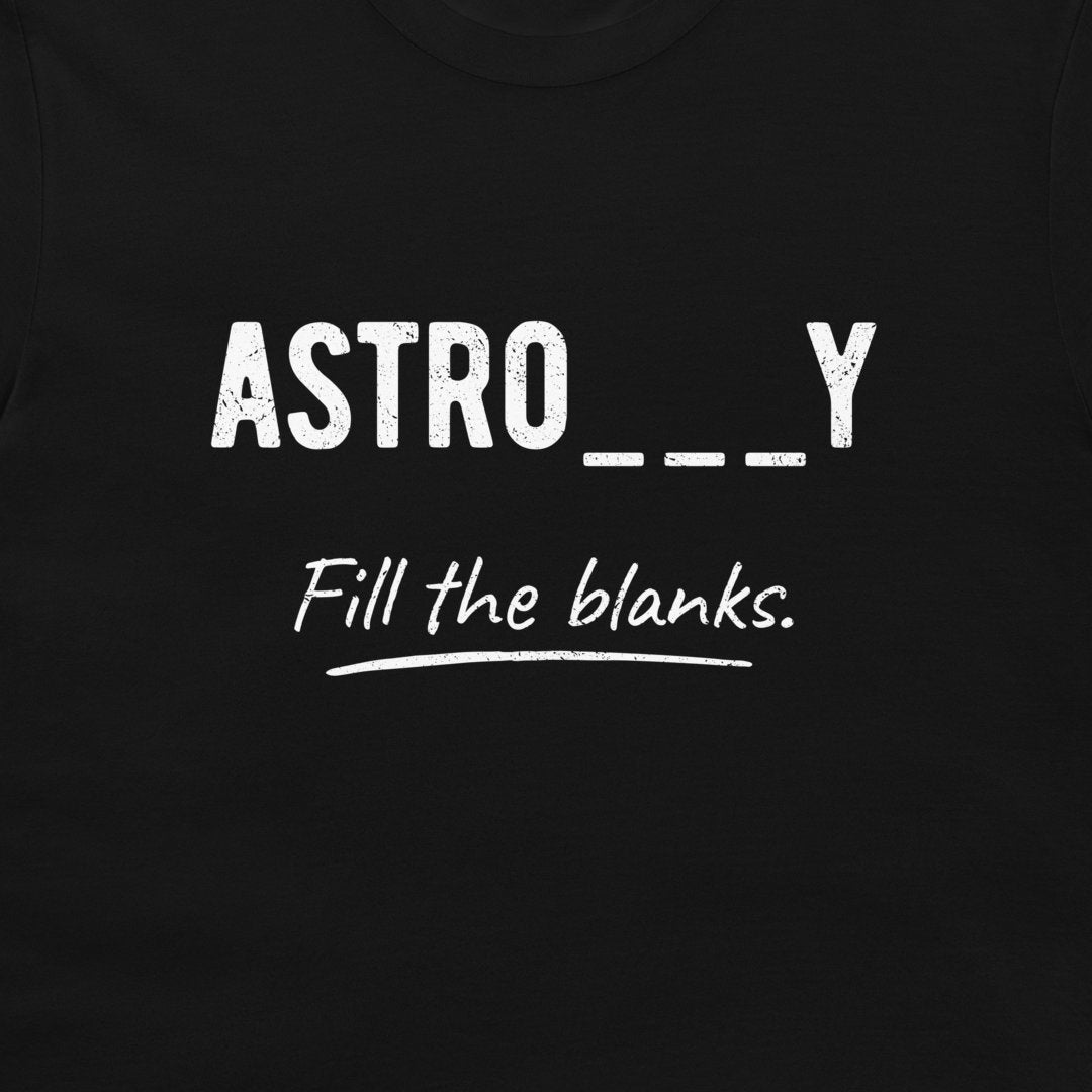 A close-up of a black t-shirt featuring a white graphic print that reads 'ASTRO___Y' in a distressed block font, with 'Fill the blanks.' in a cursive script underneath.