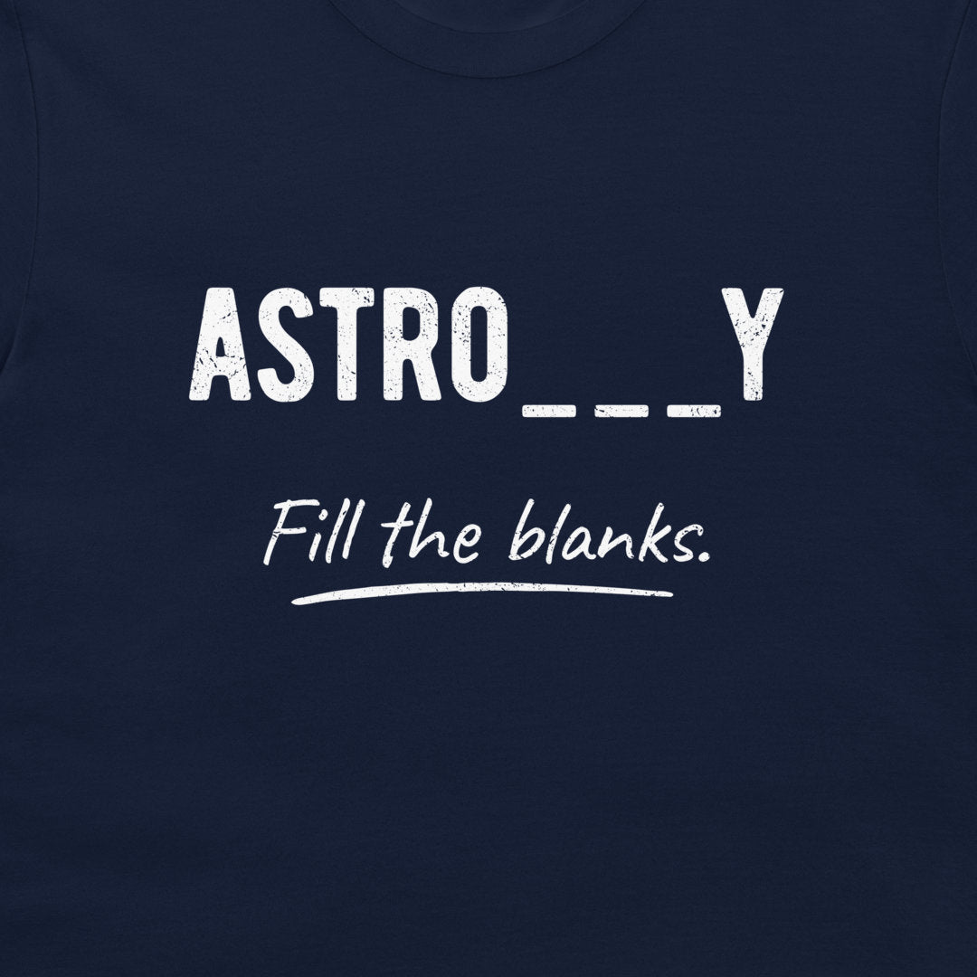 A close-up of a navy blue t-shirt featuring a white graphic print that reads 'ASTRO___Y' in a distressed sans-serif font, with 'Fill the blanks.' written below in a cursive script, underlined with a white hand-drawn stroke.