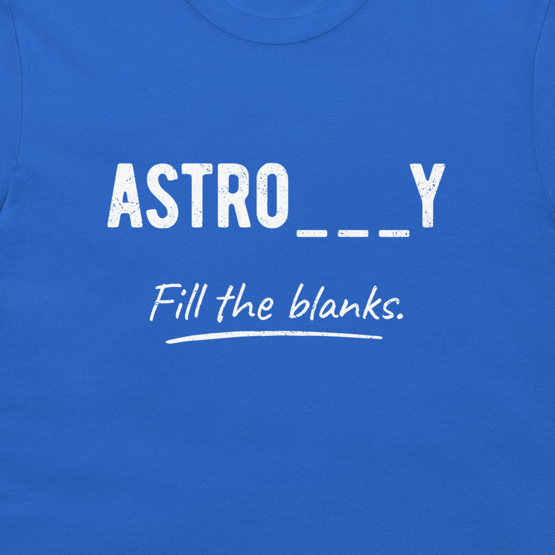 A close-up of a royal blue t-shirt featuring a white graphic print that reads 'ASTRO___Y' with 'Fill the blanks.' written underneath in a script font.
