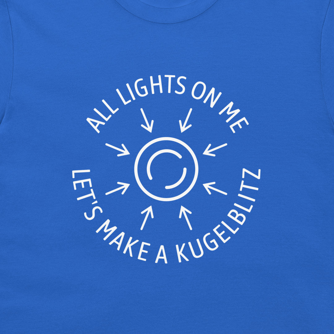 A close-up of a royal blue t-shirt featuring a white graphic print of a sun with rays and the text 'ALL LIGHTS ON ME LET'S MAKE A KUGELBLITZ'.
