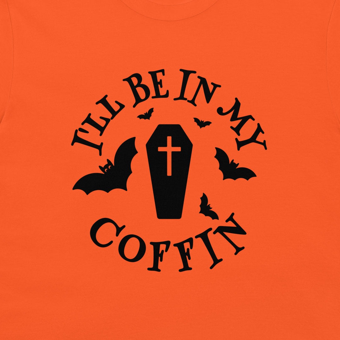 Bright orange t-shirt featuring a black graphic print of a coffin with a cross, surrounded by bats and the text 'I'LL BE IN MY COFFIN'.