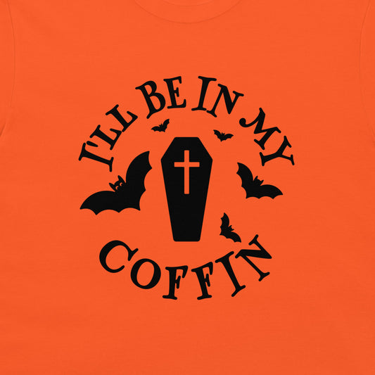 Bright orange t-shirt featuring a black graphic print of a coffin with a cross, surrounded by bats and the text 'I'LL BE IN MY COFFIN'.