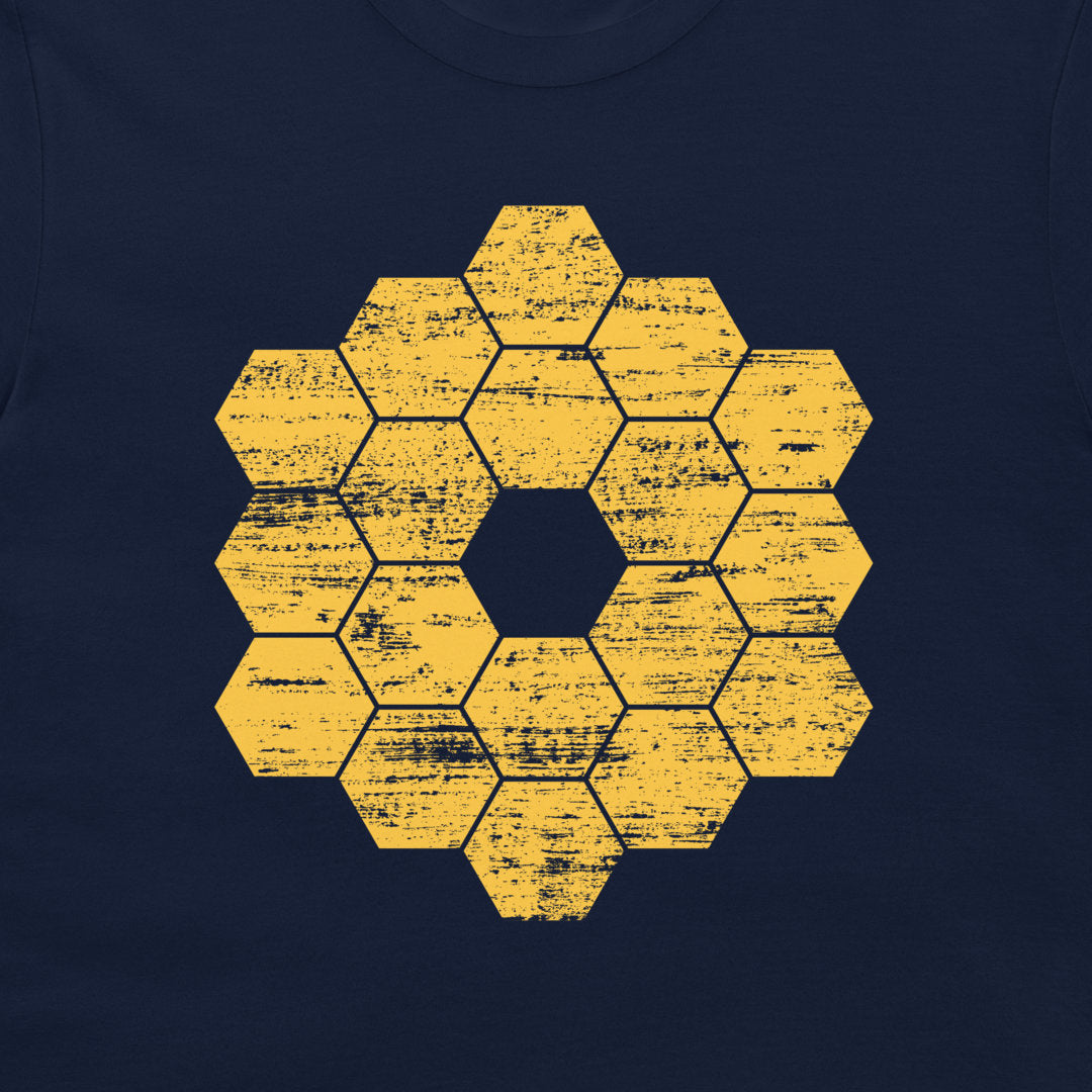 A close-up of a navy blue garment, likely a t-shirt, featuring a distressed yellow hexagonal honeycomb pattern in the center.