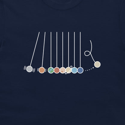 A close-up of a navy blue t-shirt featuring a white line-art graphic of a Newton's cradle with colorful balls.