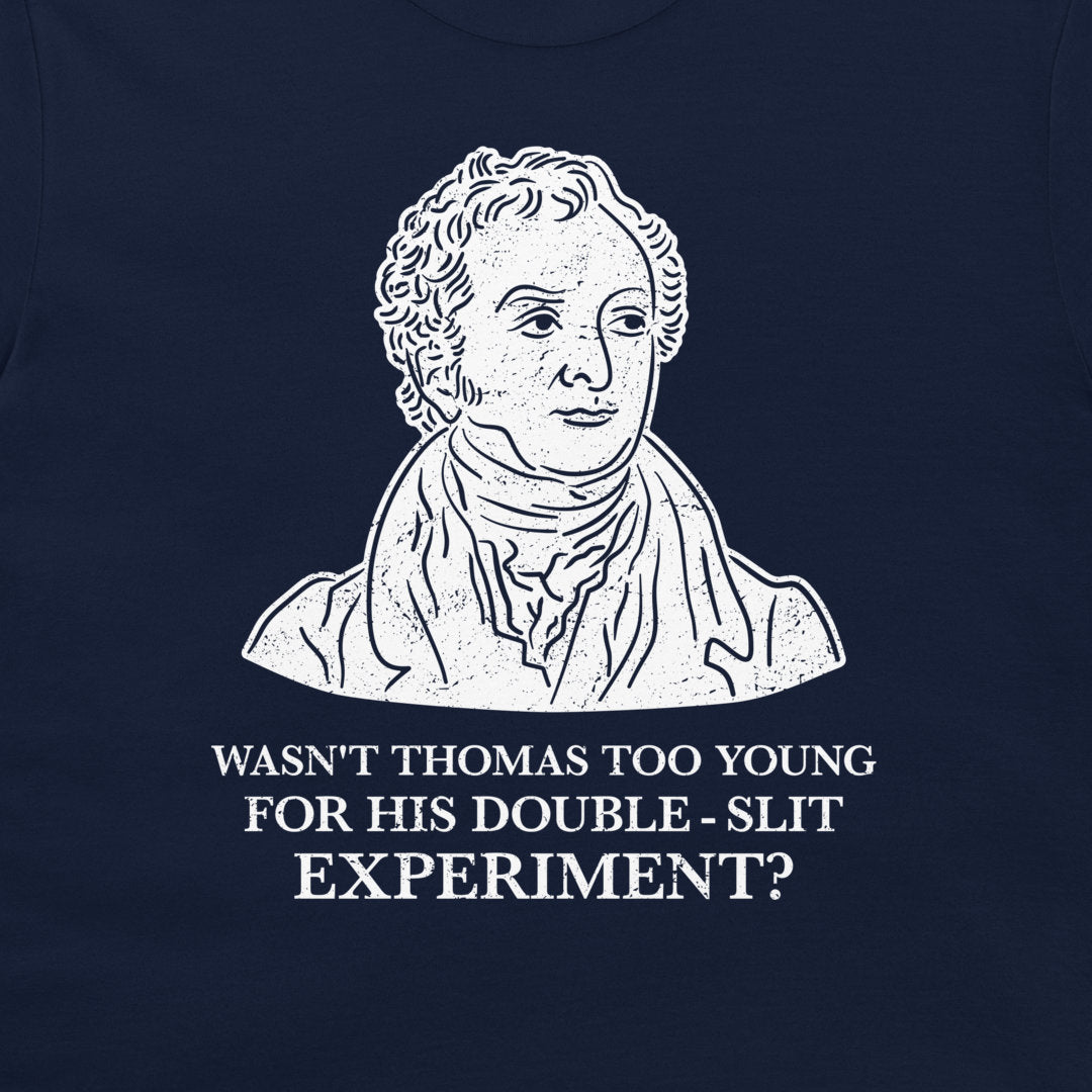 A navy blue t-shirt featuring a white graphic print of a historical portrait of Thomas Young, with the text 'WASN'T THOMAS TOO YOUNG FOR HIS DOUBLE - SLIT EXPERIMENT?' printed below.