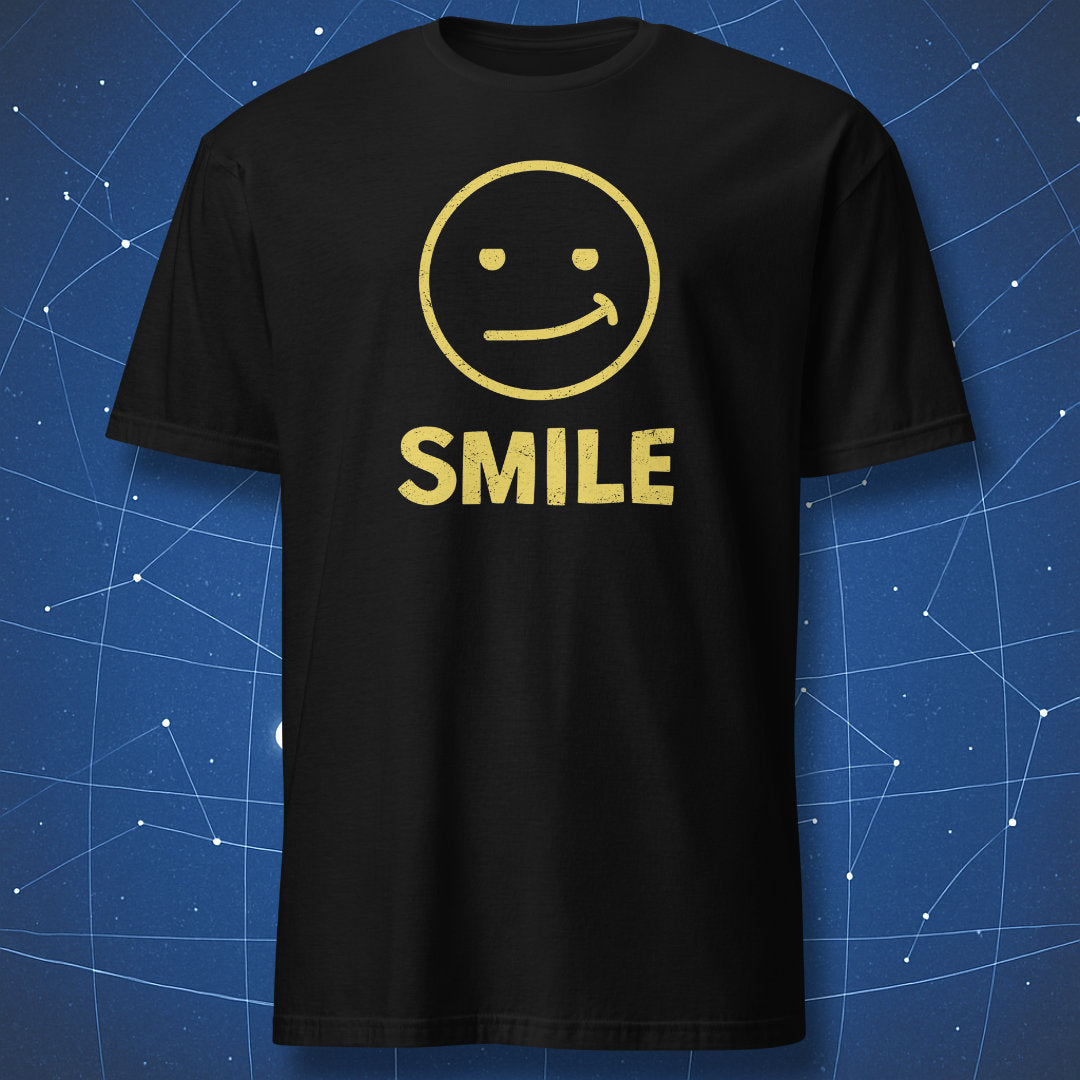 “Fake Smile” black T-shirt — white awkward smile face with bold SMILE text.