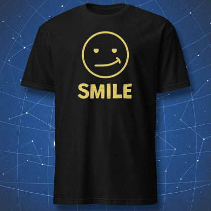 “Fake Smile” black T-shirt — white awkward smile face with bold SMILE text.