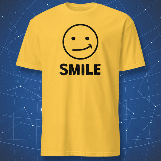 “Fake Smile” daisy yellow T-shirt with off-center awkward smile face and black text “SMILE.”