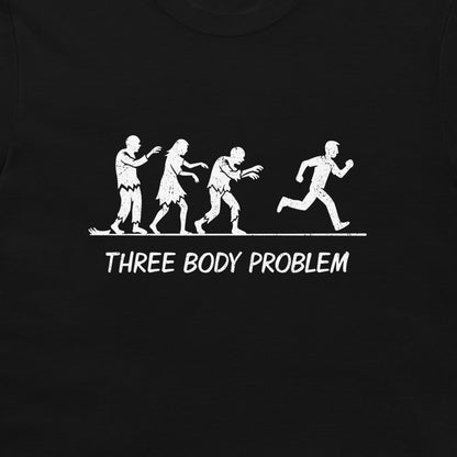 A black t-shirt featuring a white graphic print of 'Three Body Problem' showing three zombies chasing a running man, with the text 'THREE BODY PROBLEM' printed below.