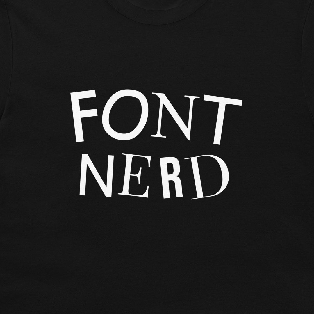 A close-up of a black t-shirt featuring the words 'FONT NERD' each letter printed in a different font across the chest.