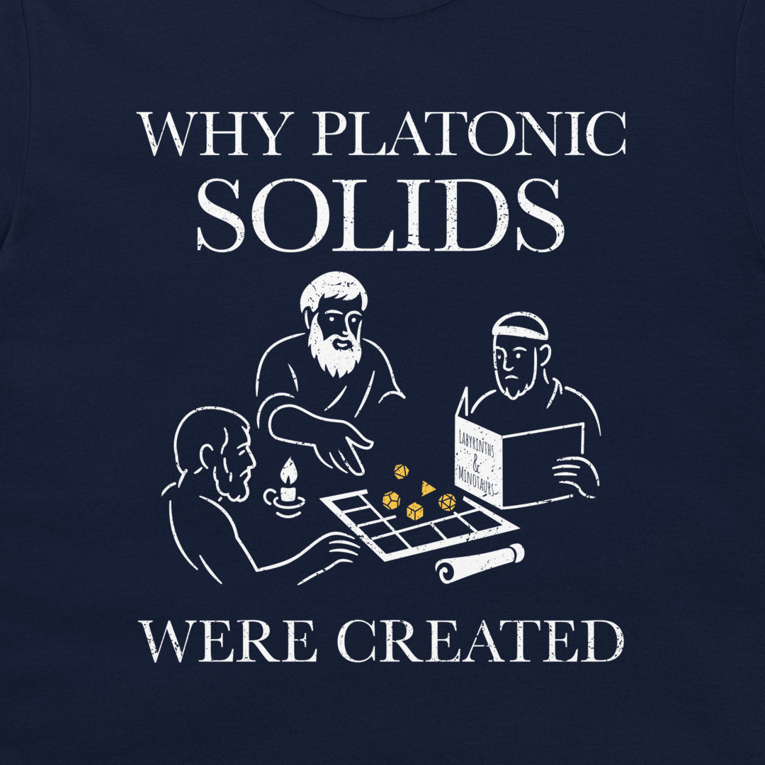 A close-up of a navy blue t-shirt, featuring a white graphic print. The text reads 'WHY PLATONIC SOLIDS WERE CREATED' surrounding a minimalist line-art illustration of three philosophers playing with dice.