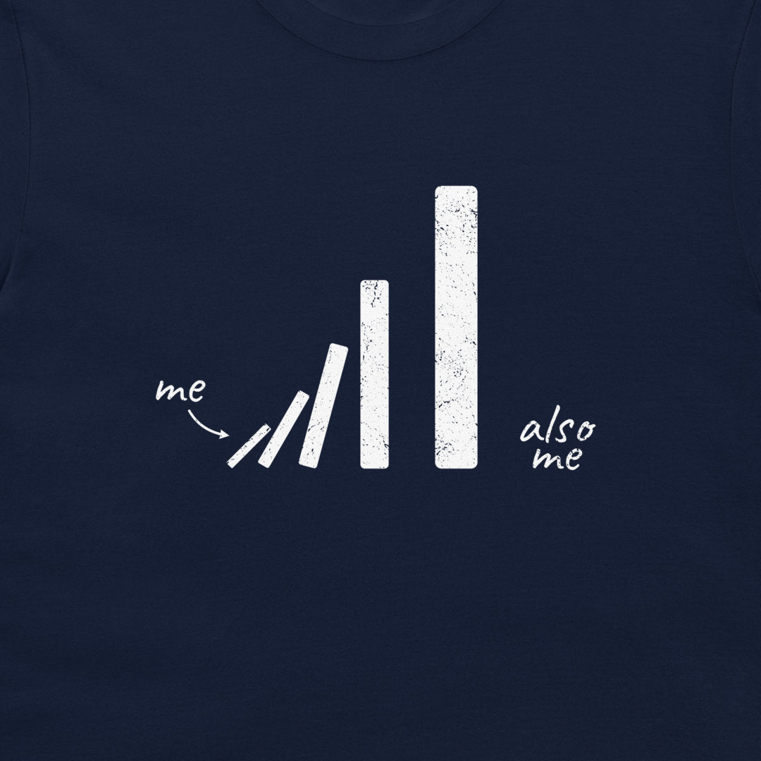 A close-up of a navy blue t-shirt featuring a white distressed graphic of falling dominoes with the text 'me' pointing to the tips and 'also me' written on the right.