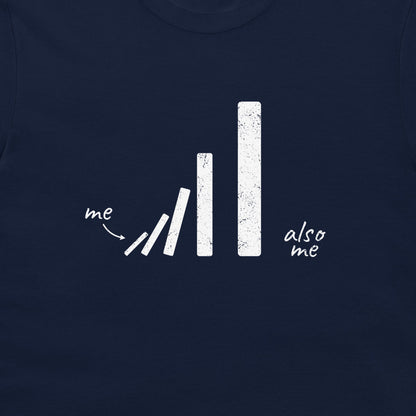 A close-up of a navy blue t-shirt featuring a white distressed graphic of falling dominoes with the text 'me' pointing to the tips and 'also me' written on the right.