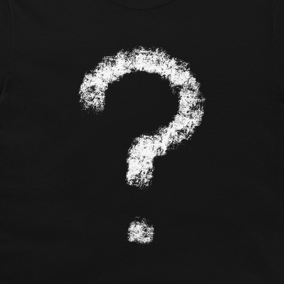 A close-up of a black t-shirt, featuring a large white chalk-style question mark graphic on the chest.