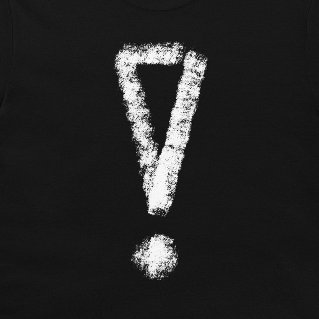 A close-up of a black t-shirt, featuring a large, distressed white exclamation mark graphic printed on the front.