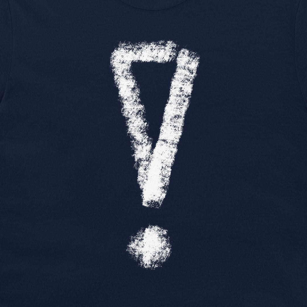 A close-up of a navy blue t-shirt, featuring a large, distressed white exclamation mark graphic printed on the chest.