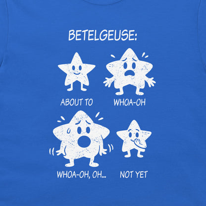 A close-up of a blue T-shirt featuring a white distressed graphic of four cartoon stars with humorous expressions and text reading 'BETELGEUSE:' and 'ABOUT TO', 'WHOA-OH', 'WHOA-OH, OH...', 'NOT YET'.