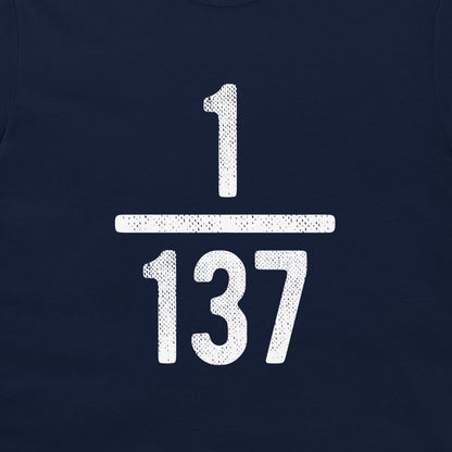 A close-up of a navy blue t-shirt, featuring a large white distressed graphic of the fraction 1/137 on the chest.