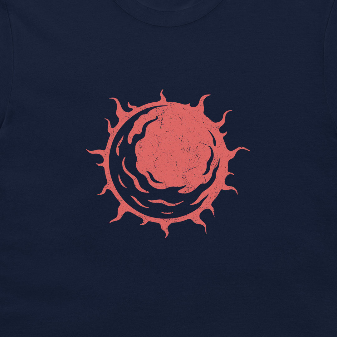 A close-up of a navy blue t-shirt featuring a distressed red circular sunburst graphic printed on the chest.
