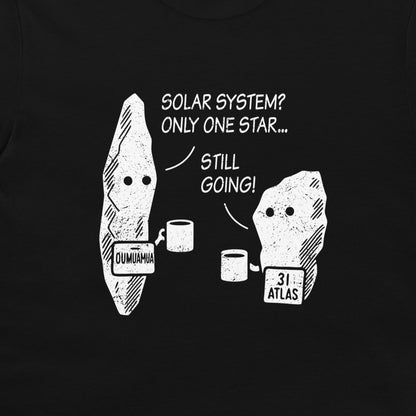 A close-up of a black garment, likely a t-shirt, featuring a white graphic print of two cartoon rocks with text that reads 'SOLAR SYSTEM? ONLY ONE STAR.