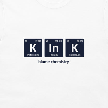 White crewneck t-shirt featuring a graphic of three dark blue periodic table style tiles spelling 'K In K' with the text 'blame chemistry' underneath.