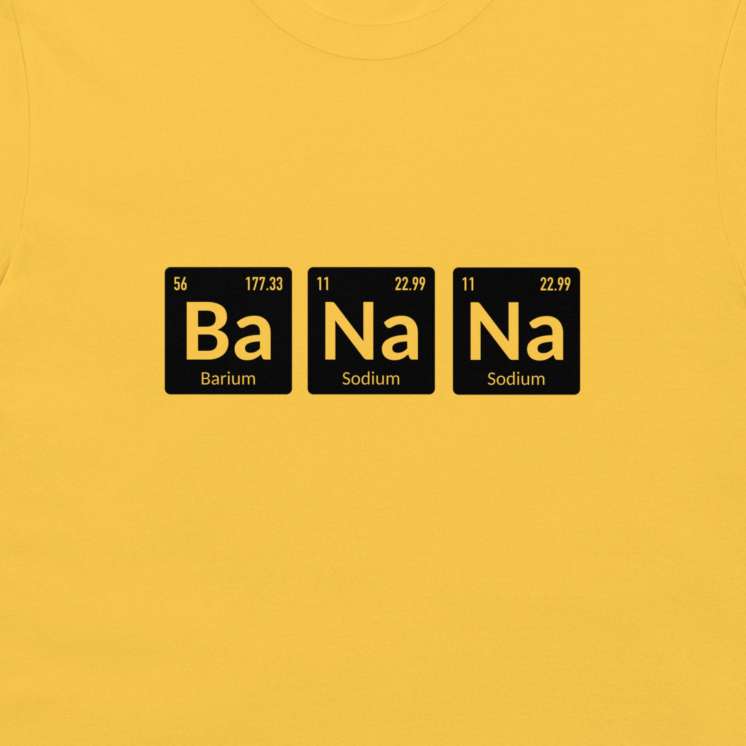 A close-up of a bright yellow t-shirt, featuring a graphic print of three black periodic table style tiles spelling out 'Ba Na Na' in yellow, with 'Barium' and 'Sodium' written below.