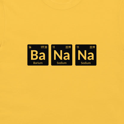 A close-up of a bright yellow t-shirt, featuring a graphic print of three black periodic table style tiles spelling out 'Ba Na Na' in yellow, with 'Barium' and 'Sodium' written below.