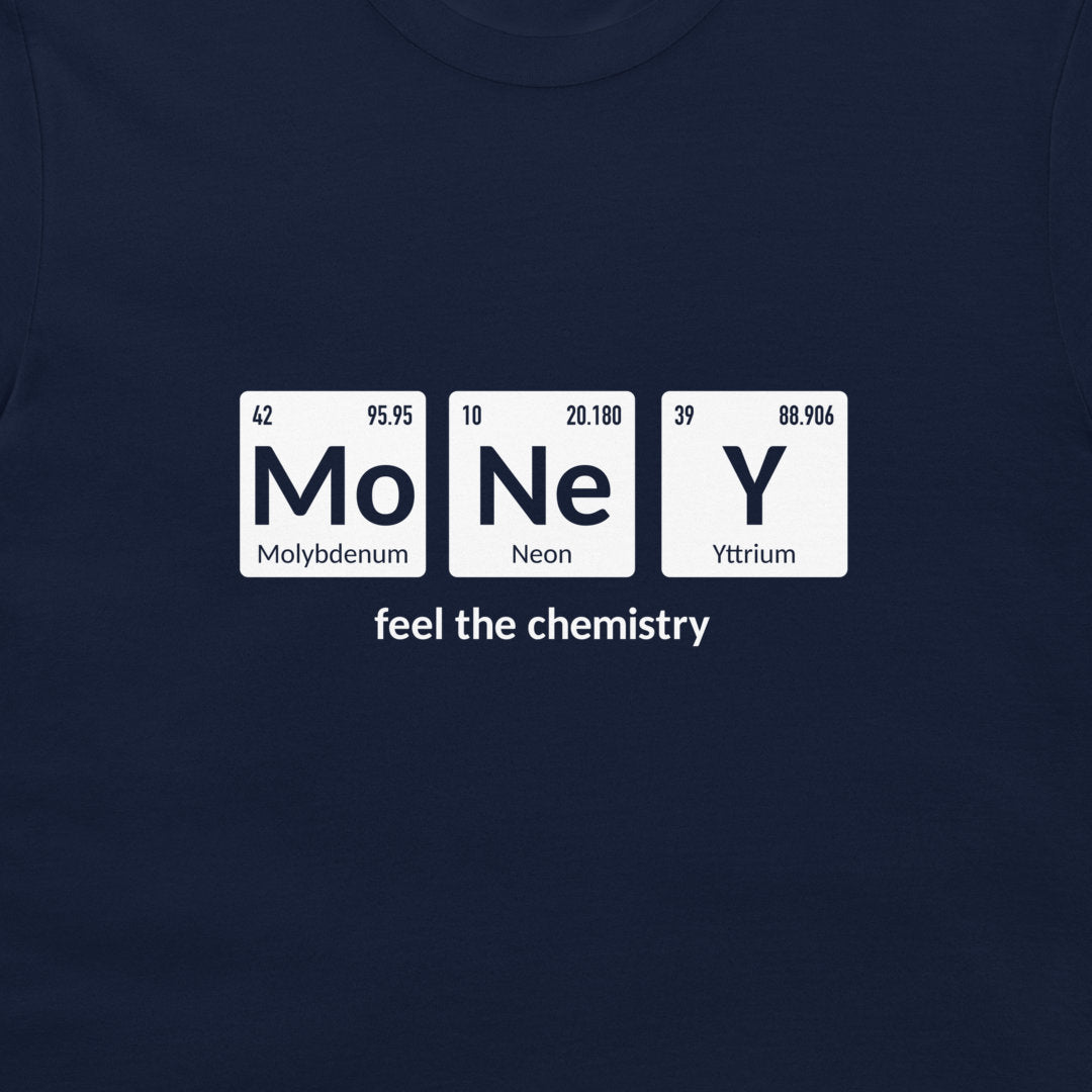 A close-up of a navy blue t-shirt featuring a white graphic print of three periodic table style tiles spelling 'MoNeY' with the text 'feel the chemistry' underneath.