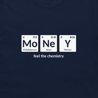 A close-up of a navy blue t-shirt featuring a white graphic print of three periodic table style tiles spelling 'MoNeY' with the text 'feel the chemistry' underneath.