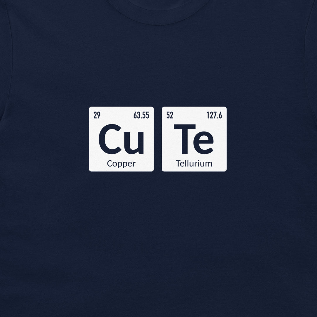 A close-up of a navy blue t-shirt, featuring a graphic print of two white periodic table tiles spelling out 'CuTe' with 'Copper' and 'Tellurium' written underneath.