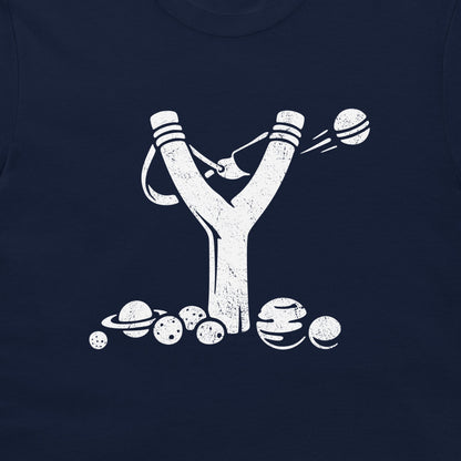 A close-up of a navy blue t-shirt, featuring a distressed white graphic of a slingshot launching planets and moons.