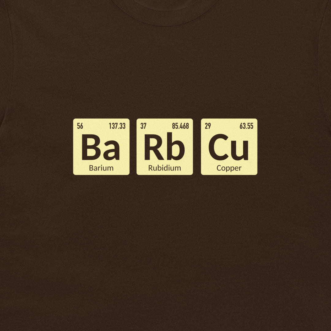 A close-up of a dark brown t-shirt featuring a graphic of three periodic table tiles spelling out 'Ba Rb Cu' in black, with pale yellow backgrounds and black text.
